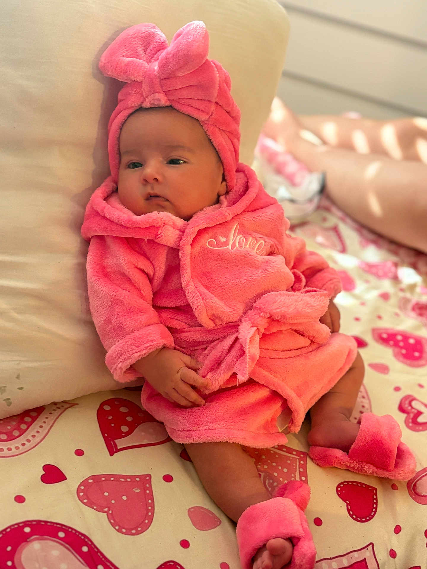 Ceylan a rejoint le concours — aidez-le/la à gagner de superbes lots ! baby, pink, robe, head_wrap, slippers, bedspread, hearts, infant, cute, soft, indoor, resting, comfortable, child, portrait, sleepwear, apparel, hand, footwear, person
