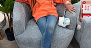 Harlee is registered to the contest to win money with this photo: armchair, bag, casual, child, decor, flooring, furniture, girl, indoor, jeans, leopard_print_shoes, orange_hoodie, people, person, plant, relaxed, shopping, shopping_mall, smoothie, store