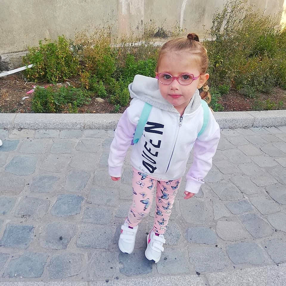 Madison a rejoint le concours — aidez-le/la à gagner de superbes lots ! asphalt, baby, baby_toddler_clothing, child, clothing, electric_blue, eyewear, face, fun, grass, outerwear, pattern, person, personal_protective_equipment, plant, recreation, road_surface, sidewalk, sleeve, toddler