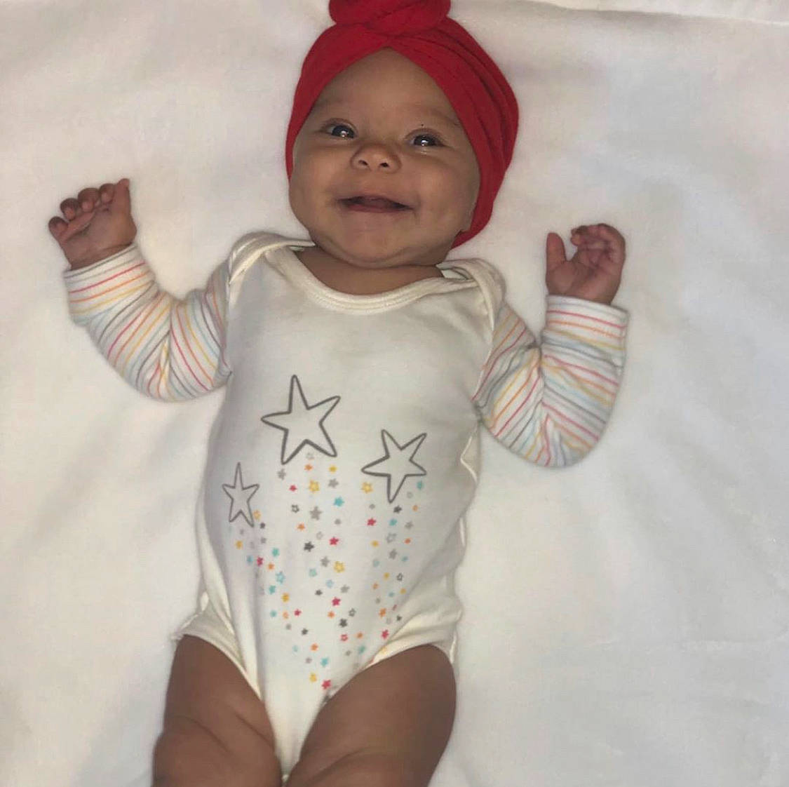Rhea is registered to the contest to win money with this photo: arm, baby, baby_products, baby_toddler_clothing, child, clothing, costume, head, headgear, headwear, infant_bodysuit, joy, pattern, person, product, sleeve, smile, t_shirt, toddler