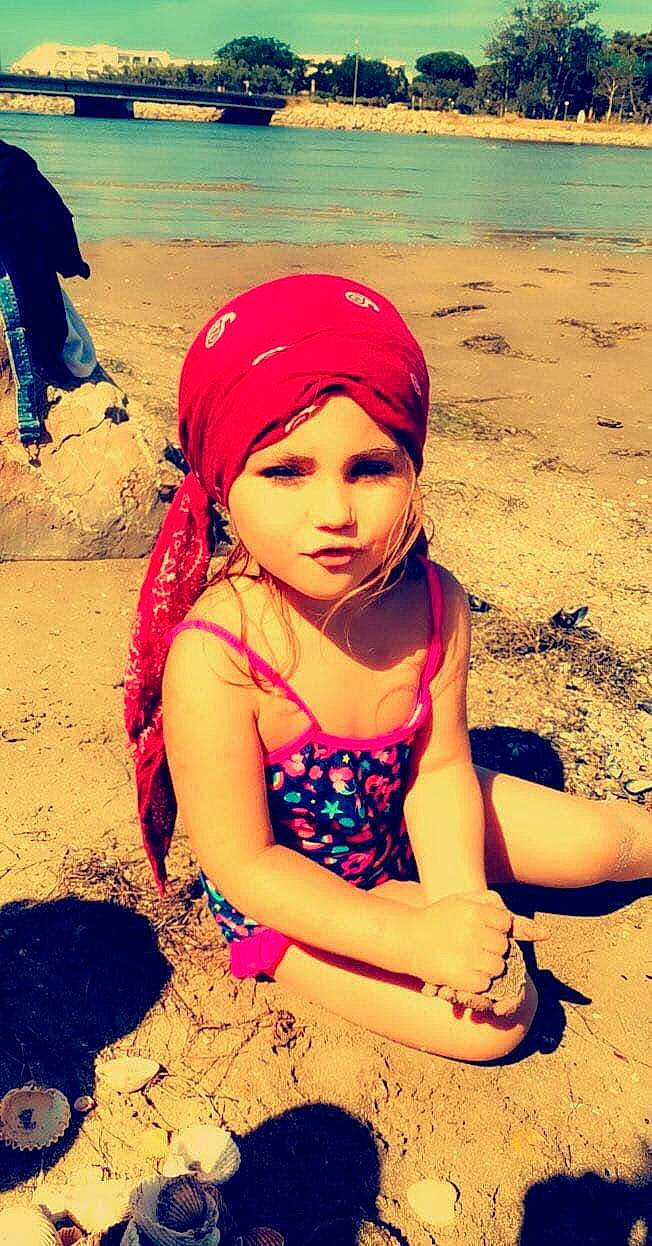 Innaya participe au concours pour gagner de l'argent avec cette photo : beach, blue, body_of_water, cap, clothing, cool, green, hand, happy, leisure, light, morning, people_in_nature, people_on_beach, person, photograph, summer, sunlight, toddler, travel