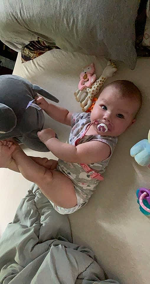 Callen is registered to the contest to win money with this photo: baby, baby_products, baseball_cap, chair, child, comfort, fun, gesture, glove, hairstyle, happy, leisure, person, personal_protective_equipment, play, room, sandal, sitting, skin, toddler