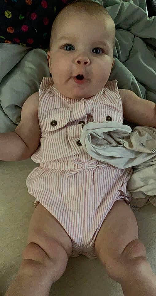 Callen is registered to the contest to win money with this photo: baby, baby_toddler_clothing, cheek, comfort, eye, finger, happy, human_body, joint, knee, lip, mouth, neck, organ, pattern, person, skin, sleeve, textile, thigh