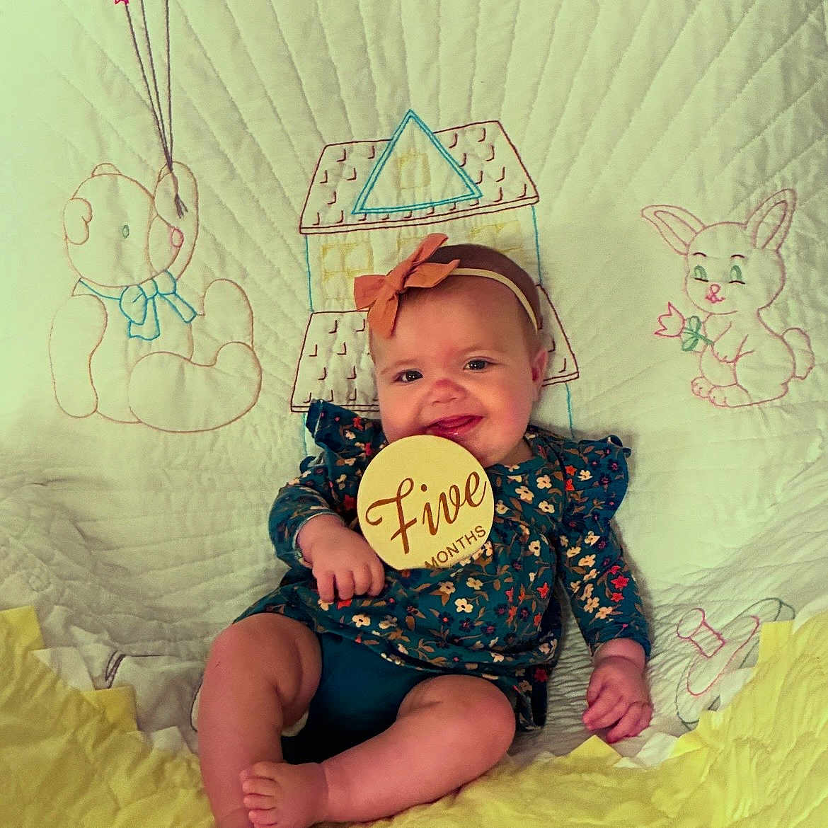 Rubyann is registered to the contest to win money with this photo: baby, infant, child, smiling, portrait, sitting, milestone, five_months, headband, bow, floral_clothing, blanket, quilt, nursery, stuffed_animal, teddy_bear, rabbit, balloons, castle, indoor