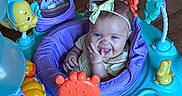Rubyann joined the competition — help win amazing prizes! baby, child, infant, smiling, happy, tongue_out, bow_headband, activity_center, baby_toy, colorful, playtime, indoor, wood_floor, seated, portrait, face, toy_robot, plush_toy, plastic_toys, family_photo