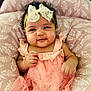 baby, infant, child, smile, face, headband, bow, dress, pink, peach, cushion, pattern, soft, comfortable, cute, happy, portrait, indoors, person, baby_girl