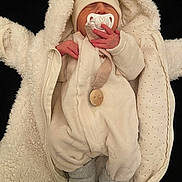 Ezio a rejoint le concours — aidez-le/la à gagner de superbes lots ! newborn, baby, pacifier, infant, clothing, hat, socks, blanket, sleeping, cute, soft, warm, cozy, fur, onesie, bundle, child, person, indoors, portrait