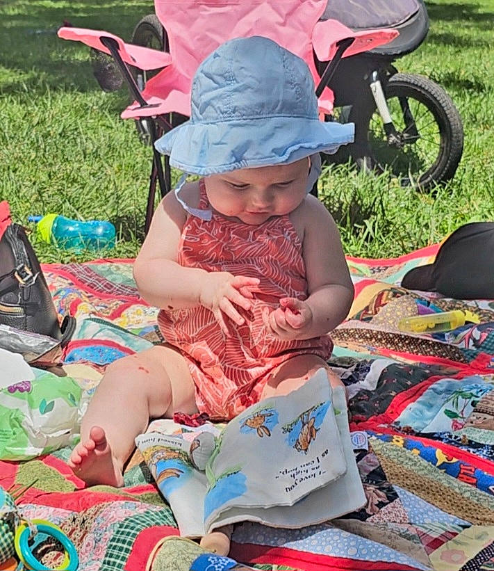 Ahna joined the competition — help win amazing prizes! baby, child, event, fun, grass, green, hat, headwear, lap, leisure, people, person, pink, plant, product, recreation, sharing, summer, sun_hat, tire