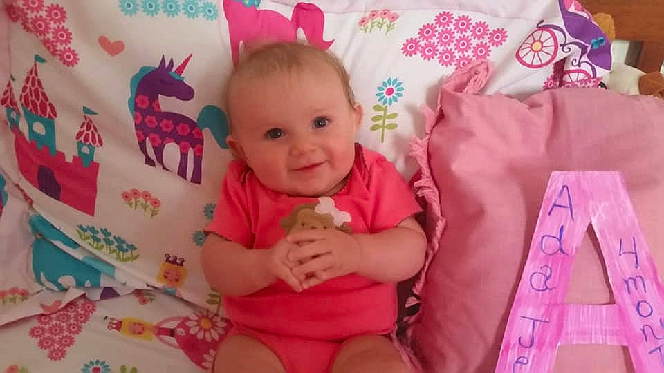 Ada is registered to the contest to win money with this photo: baby, baby_products, baby_toddler_clothing, cheek, child, finger, magenta, nap_mat, person, pink, play, product, skin, smile, textile, toddler