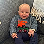 Ted joined the competition — help win amazing prizes! baby, child, smiling, sitting, couch, sweater, blue_pants, toy_truck_design, face, hands, feet, sock, indoor, cozy, happy, portrait, person, furniture, blanket, home