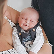 Ted joined the competition — help win amazing prizes! baby, sleeping, smile, infant, person, adult, arms, clothing, striped_dress, watch, teddy_bear, cute, closeup, portrait, holding, peaceful, indoor, soft_light, skin, hand