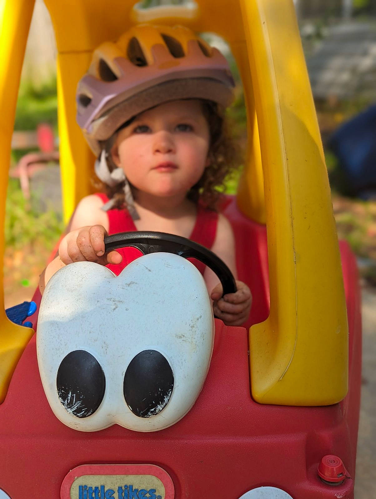 Presley is registered to the contest to win money with this photo: baby, bicycle_helmet, bumper, cap, child, facial_expression, fun, happy, headwear, helmet, leisure, motor_vehicle, person, personal_protective_equipment, playground, recreation, snapshot, teddy_bear, toddler, vacation