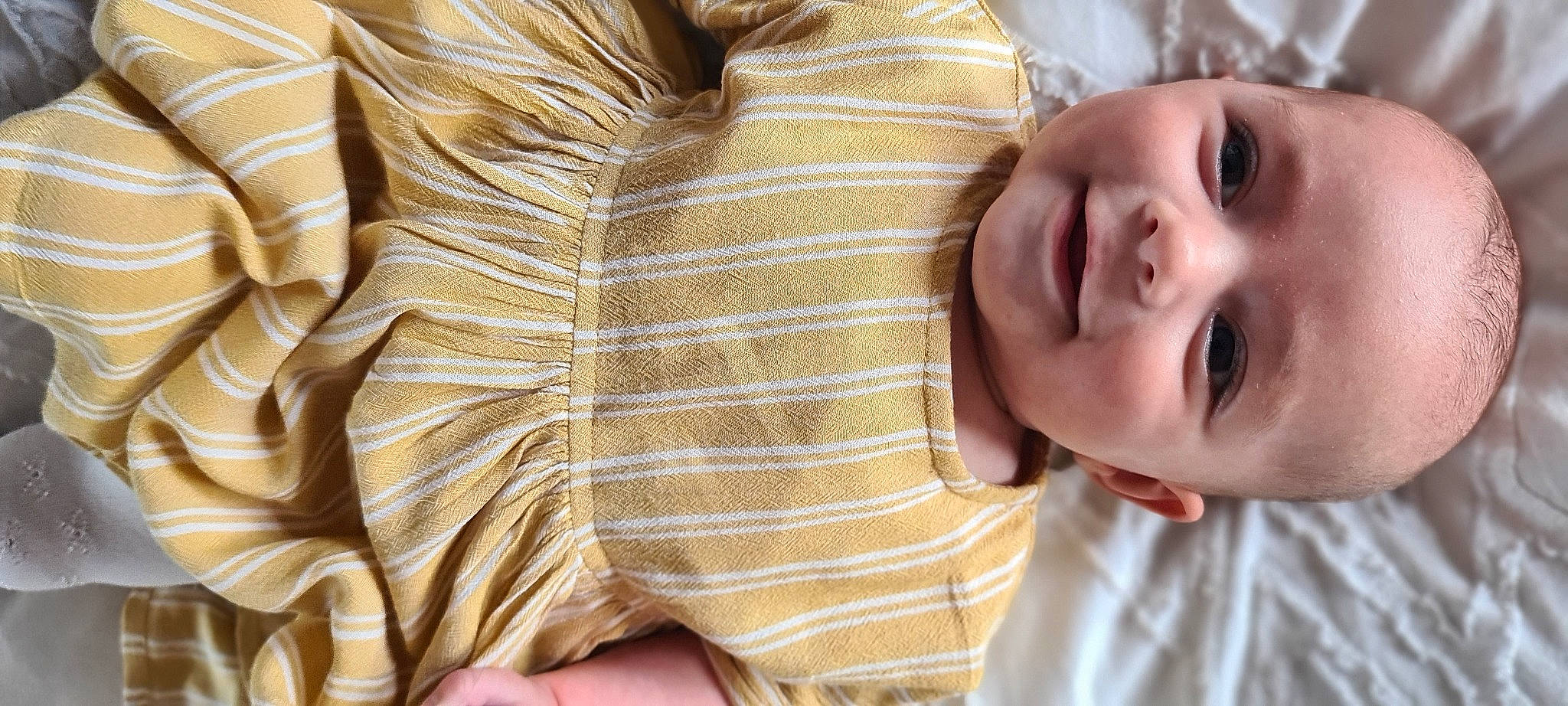 Aura is registered to the contest to win money with this photo: baby, child, facial_expression, happy, joy, neck, person, skin, smile, textile, toddler, yellow