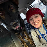 Peanut Butter is registered to the contest to win money with this photo: animal, braids, car, casual, closeup, companion, daylight, dog, friendship, happy, hat, hoodie, outdoor_view, pet, portrait, seatbelt, smile, vehicle_interior, window, woman