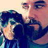 Laïka a rejoint le concours — aidez-le/la à gagner de superbes lots ! man, beard, puppy, dog, selfie, portrait, close_up, face, eyes, looking_sideways, black_and_tan, pet, companion, indoors, warm_lighting, filtered_photo, casual, headshot, friendly, animal