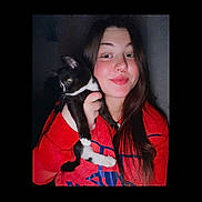 Nala-Rose is registered to the contest to win money with this photo: animal, black_cat, casual, cat, cute, face, friendship, happy, holding, human, indoor, long_hair, looking_away, pet, portrait, red_hoodie, smile, white_paws, woman, young_adult