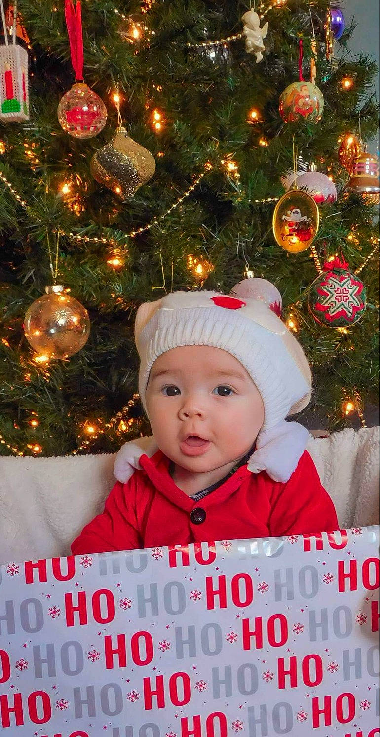 Mylah is registered to the contest to win money with this photo: baby, child, christmas, christmas_decoration, christmas_eve, christmas_ornament, christmas_tree, conifer, event, evergreen, happy, head, headwear, holiday, holiday_ornament, light, ornament, person, sleeve, toddler