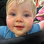 Teddy is registered to the contest to win money with this photo: toddler, child, face, blue_eyes, blond_hair, close_up, indoor, person, baby, expression, curious, clothing, hand, adult, background, seated, portrait, skin, young, people