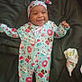 Kymani is registered to the contest to win money with this photo: baby, infant, smiling, onesie, hat, cute, lying_down, patterned_clothing, donuts, cupcakes, hearts, dark_background, comfort, happy, child, fabric, floral, soft, cozy, playful