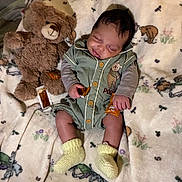 Dashine is registered to the contest to win money with this photo: baby, teddy_bear, blanket, sleeping, infant, soft_toy, cute, child, cozy, yellow_socks, green_outfit, animal_print, bedtime, peaceful, indoors, plush, small_packets, resting, portrait, comfort