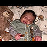 Dashine is registered to the contest to win money with this photo: baby, smiling, teddy_bear, blanket, animal_print, infant, cute, clothing, cozy, sleeping, child, soft_toy, portrait, happy, indoors, young_child, face, hand, comfort, resting