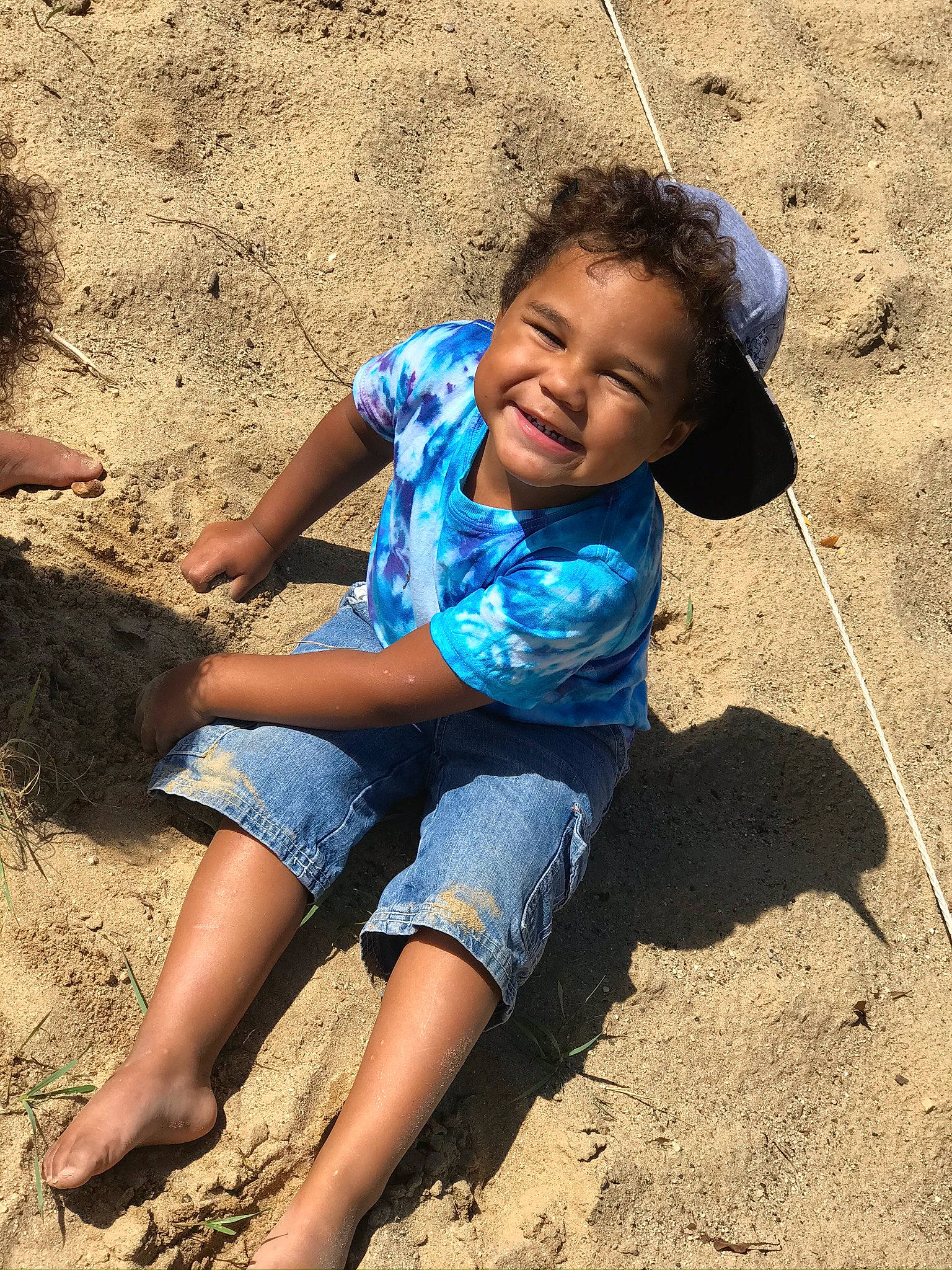 Davien is registered to the contest to win money with this photo: adaptation, barefoot, child, electric_blue, foot, fun, happy, human, human_leg, landscape, leg, leisure, people_in_nature, person, sand, sitting, smile, soil, thigh, toddler