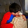 Alya participe au concours pour gagner de l'argent avec cette photo : child, baby, blanket, chair, cuddle, family, indoor, love, person, portrait, red_clothing, blue_clothing, toddler, young_child, affection, cozy, soft_texture, head, sitting, together