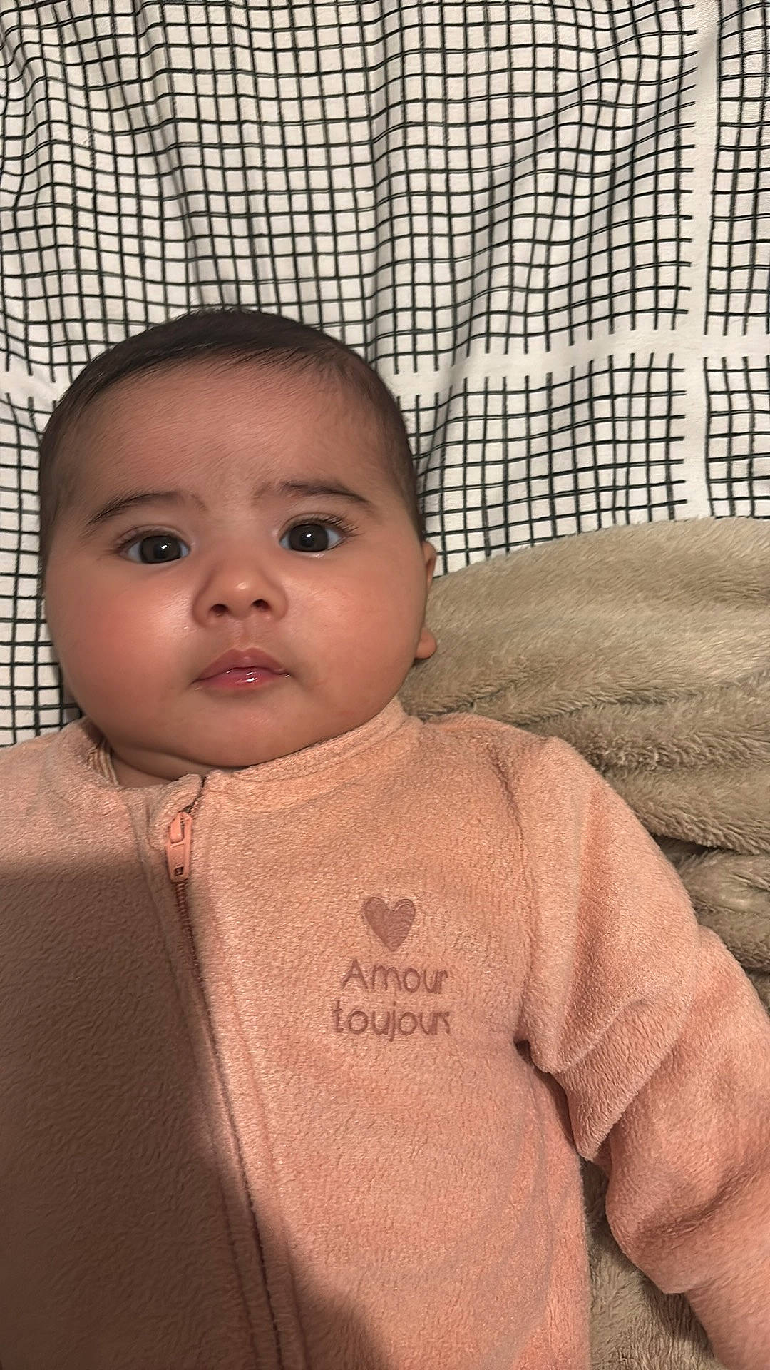 adorable, baby, blanket, child, closeup, clothing, cute, expression, eyes, face, head, indoors, infant, onesie, pattern, portrait, skin, sleepwear, soft_texture, young