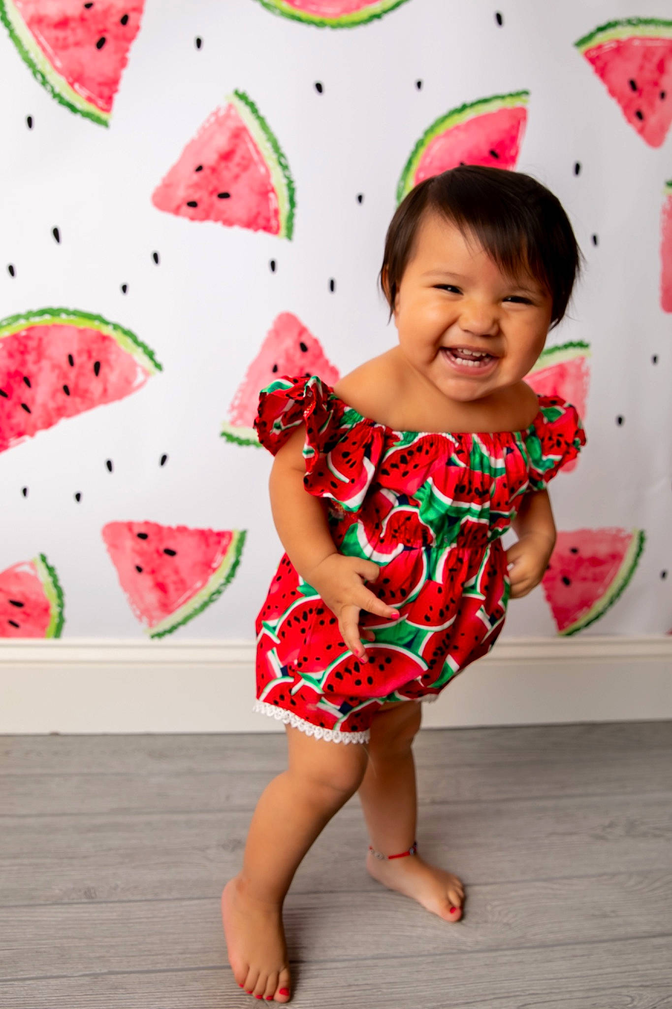 Anahi is registered to the contest to win money with this photo: arm, baby_toddler_clothing, clothing, face, fun, happy, head, human_body, joy, leg, one_piece_garment, pattern, people, person, pink, product, red, skin, sleeve, smile