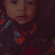 Asa is registered to the contest to win money with this photo: baby, child, face, hoodie, clothing, portrait, closeup, infant, cute, looking, young, expression, eyes, person, apparel, dark_background, soft_light, indoor, head, fashion