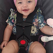Oakleigh Mae is registered to the contest to win money with this photo: baby, child, car_seat, pink_bow, headband, smile, floral_outfit, sandal, toy, infant, seatbelt, cute, happy, person, portrait, baby_clothes, baby_accessories, safety, indoor, closeup