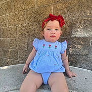 Kylie joined the competition — help win amazing prizes! child, toddler, baby, portrait, sitting, outdoor, red_bow, blue_dress, floral_dress, brick_wall, concrete, steps, looking_at_camera, face, eyes, light_hair, rosy_cheeks, fashion, daylight, photograph