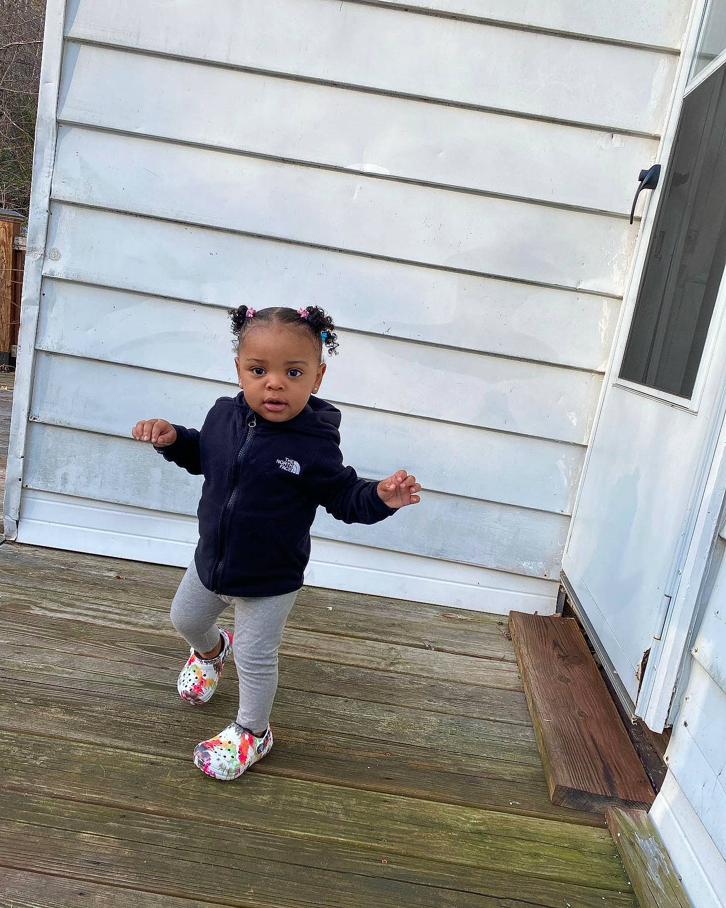 Lailah joined the competition — help win amazing prizes! baby_toddler_clothing, child, deck, denim, flooring, fun, grass, happy, house, leisure, people_in_nature, person, play, siding, sitting, toddler, tree, walking, winter, wood