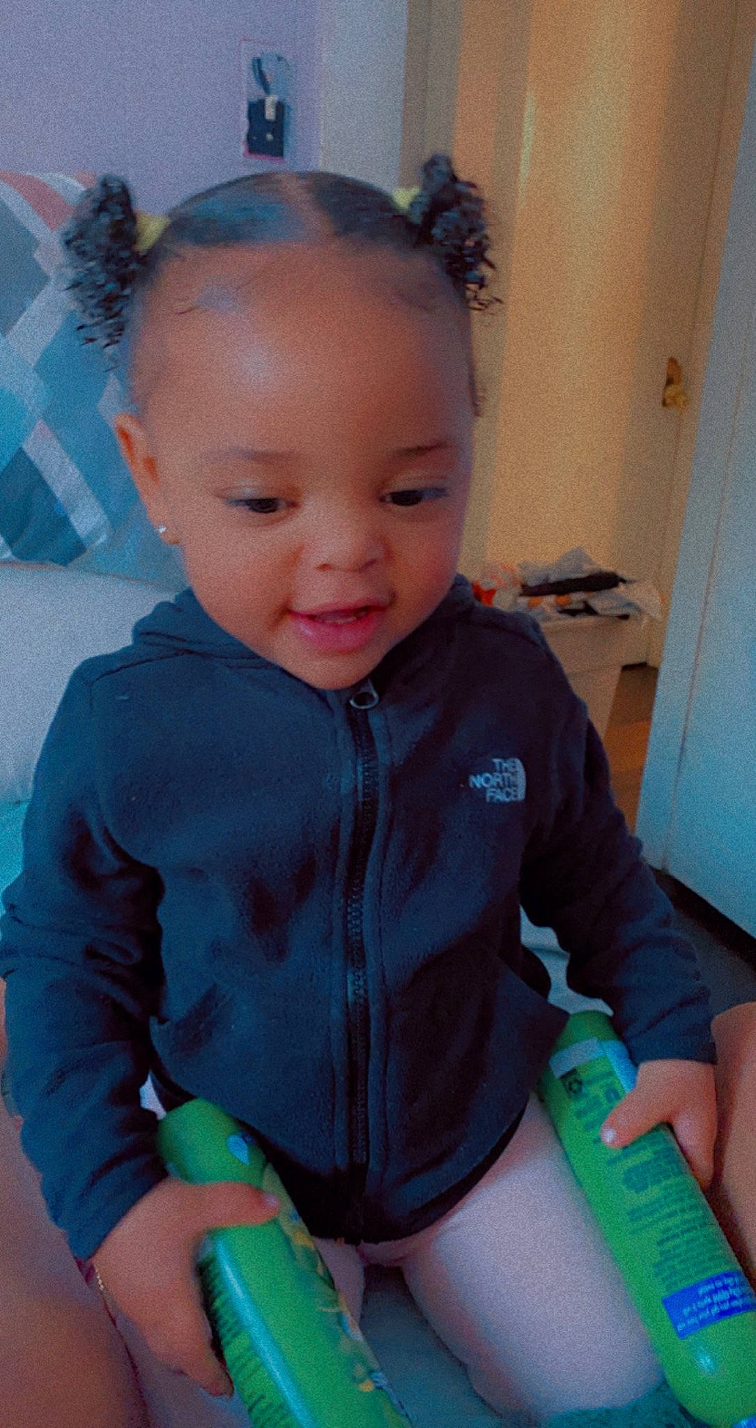 Lailah is registered to the contest to win money with this photo: baby, baby_toddler_clothing, blue, cheek, child, door, electric_blue, eyebrow, finger, fun, green, happy, iris, person, room, sitting, skin, sleeve, smile, t_shirt