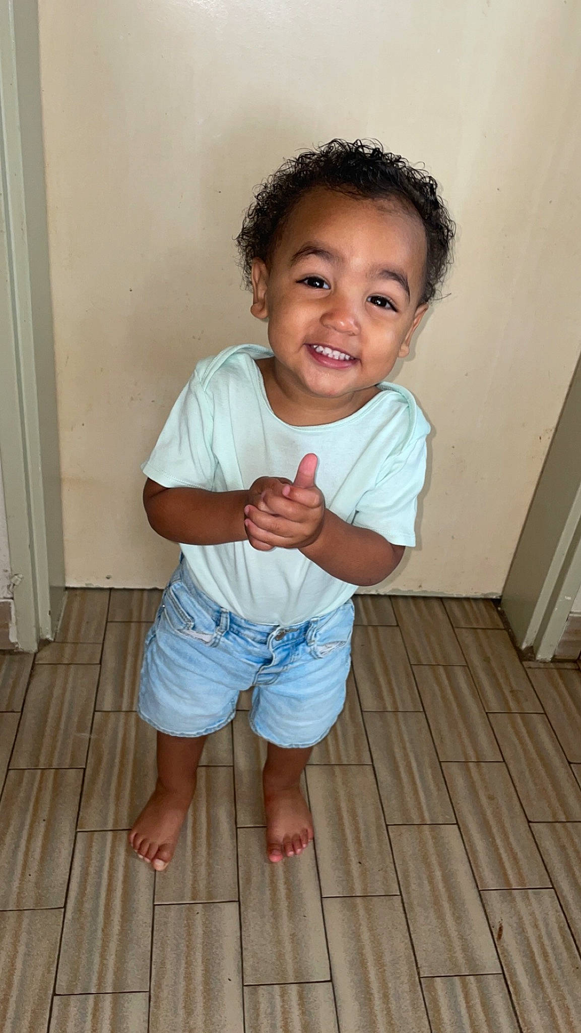Eden participe au concours pour gagner de l'argent avec cette photo : baby_toddler_clothing, cheek, child, flash_photography, floor, flooring, fun, happy, hardwood, human_leg, joy, nose, person, shorts, skin, sleeve, smile, standing, t_shirt, toddler