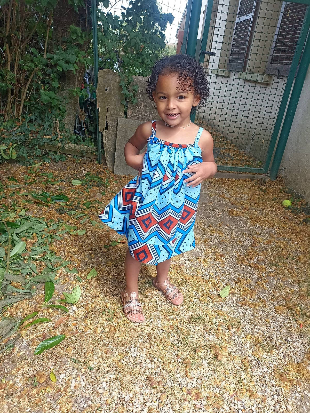 Angelina participe au concours pour gagner de l'argent avec cette photo : baby_toddler_clothing, day_dress, electric_blue, facial_expression, fun, grass, grass_family, happy, house, human_body, joy, leisure, natural_environment, one_piece_garment, pattern, people_in_nature, person, plant, toddler, tree