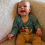 baby, child, smiling, sitting, armchair, clothing, blue_socks, beige, indoor, happy, person, cute, plush, mickey_mouse, pluto, infant, cozy, portrait, young_child, furniture