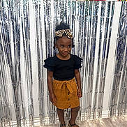 Kera is registered to the contest to win money with this photo: accessories, child, clothing, face, female, footwear, girl, hair, head, jewelry, person, photography, portrait, sandal, shoe, shorts, skirt, sleeve, standing, student