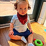 James joined the competition — help win amazing prizes! toddler, child, baby, indoor, sitting, curly_hair, topknot, red_bib, blue_shorts, white_socks, wooden_floor, toy, green_toy, sunlight, window, glass_door, casual_clothing, young_child, cute, portrait