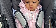 Araceli is registered to the contest to win money with this photo: baby, child, clothing, cute, gray, headwear, hoodie, infant, outdoor, person, pink, plush_toy, portrait, safety_harness, seatbelt, serious_face, sitting, stroller, tiara, young_child