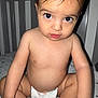 baby, baby_bed, bed, big_eyes, child, closeup, crib, cute, diaper, expression, furniture, indoors, infant, looking_at_camera, person, portrait, sitting, skin, toddler, young_child