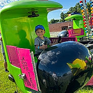 Izlan joined the competition — help win amazing prizes! amusement_ride, black, blue_sky, boy, cap, child, clouds, daylight, fair, fun, grass, green, hands, helicopter_ride, outdoor, pink, playful, seat, smiling, sunny