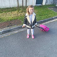 Helena Catalia participe au concours pour gagner de l'argent avec cette photo : backpack, child, clothing, curb, daylight, expression, girl, grass, jacket, outdoor, person, pink, polka_dot, sandals, sidewalk, standing, street, tights, urban, wall