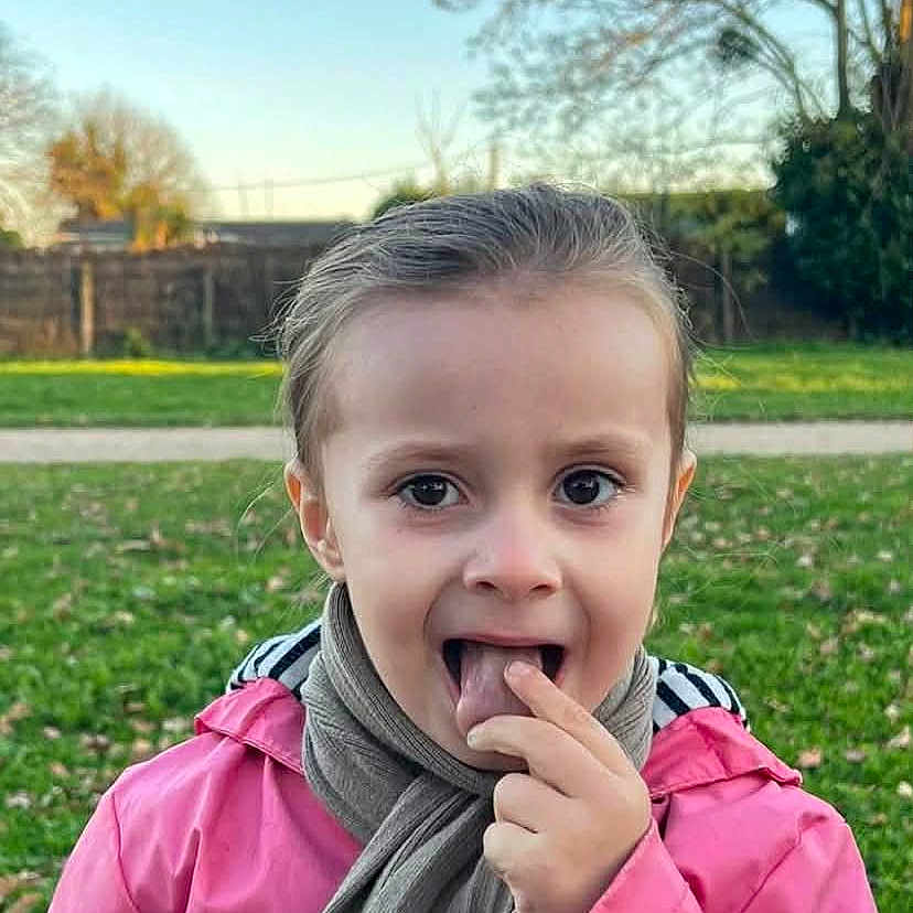 Helena Catalia a rejoint le concours — aidez-le/la à gagner de superbes lots ! casual_clothing, child, curious, daylight, expression, face, fall, grass, nature, outdoor, park, person, pink_jacket, playful, portrait, scarf, sky, tree, wooden_table, young
