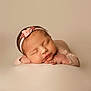 arms, baby, beige_background, calm, closed_eyes, cute, flower, hands, head, headband, infant, newborn, peaceful, pink, portrait, resting, skin, sleeping, soft_lighting, studio