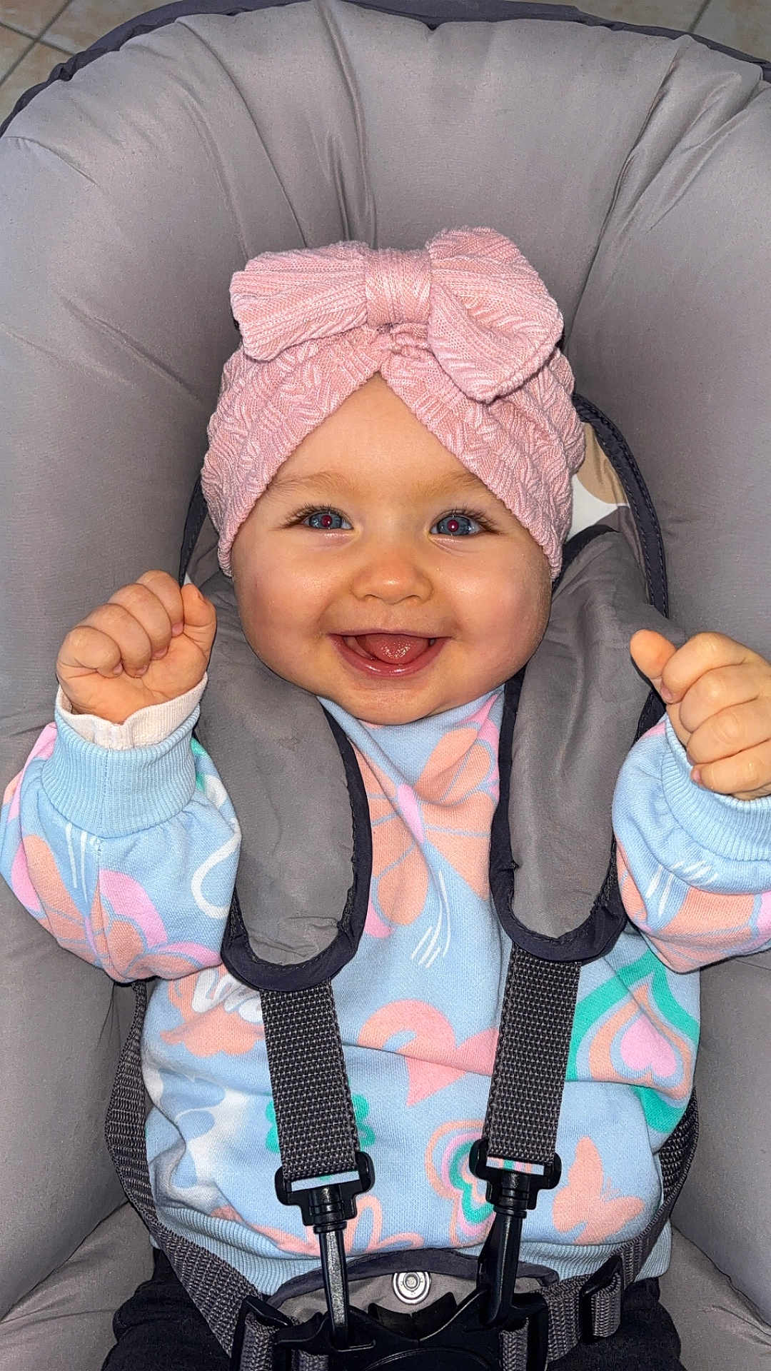 Maëline participe au concours pour gagner de l'argent avec cette photo : baby, child, smiling, headband, pink_bow, car_seat, sweater, straps, happy, infant, cute, indoors, child_seat, clothing, person, portrait, baby_girl, seatbelt, joyful, raising_fists