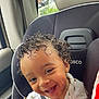 toddler, child, curly_hair, smile, car_seat, seatbelt, vehicle_interior, happy, portrait, baby, face, person, clothing, window, daylight, skin, cute, young_child, indoors, safety