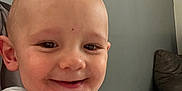 Camille participe au concours pour gagner de l'argent avec cette photo : baby, casual, child, couch, face, furniture, happy, head, home, indoor, light, person, portrait, seated, shirt, smile, toddler, wall_art, window, young_child