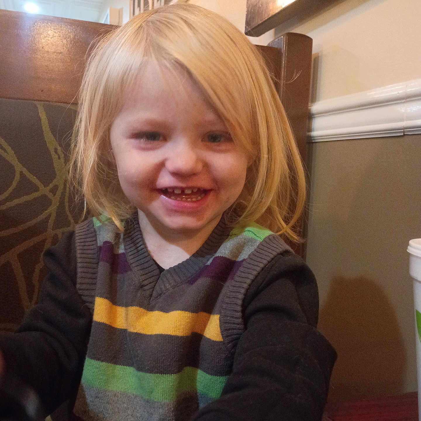 Anubis joined the competition — help win amazing prizes! child, smiling, blonde_hair, striped_sweater, indoor, restaurant, table, wooden_chair, happy, portrait, face, person, cute, casual_clothing, young, kid, seat, wall, lighting, dining