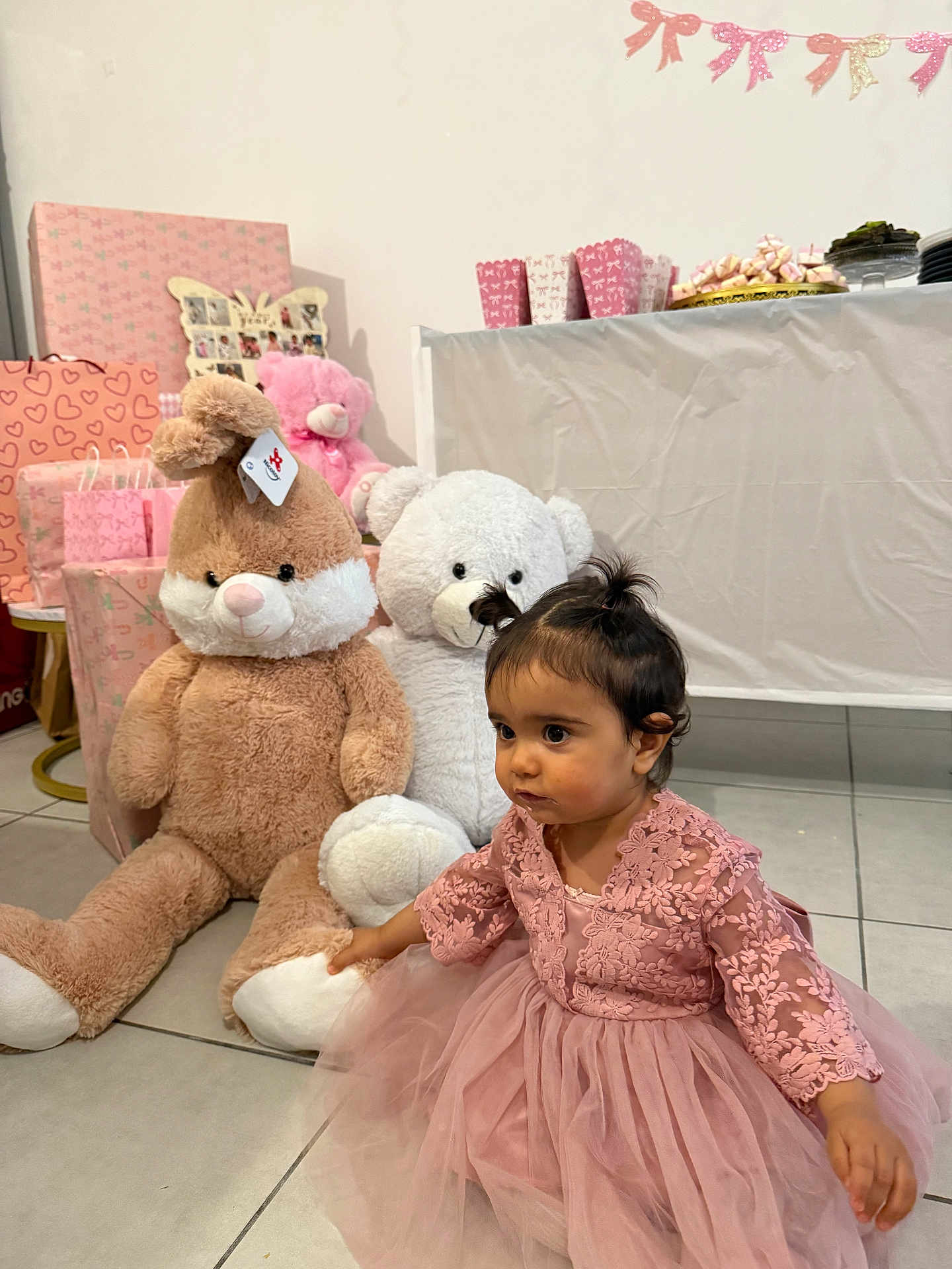 Zerda Ulbeki participe au concours pour gagner de l'argent avec cette photo : child, toddler, pink_dress, stuffed_toy, teddy_bear, birthday_party, gifts, gift_wrap, plush_toy, party_decor, cake_plate, table, tile_floor, indoor, lace, tulle, sitting, portrait, hair_topknot, cute